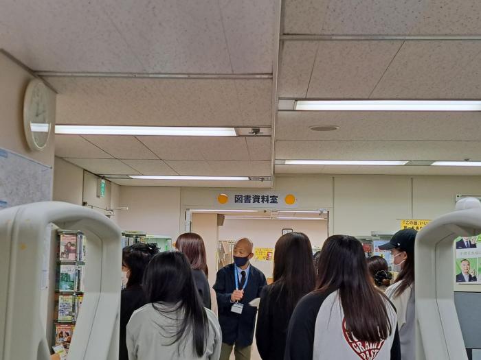 学生が図書資料室の説明を聞いている写真