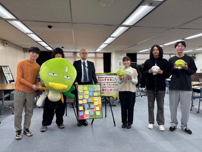 マスコットキャラクターとともに、参加者が並んで記念撮影をしている様子です。